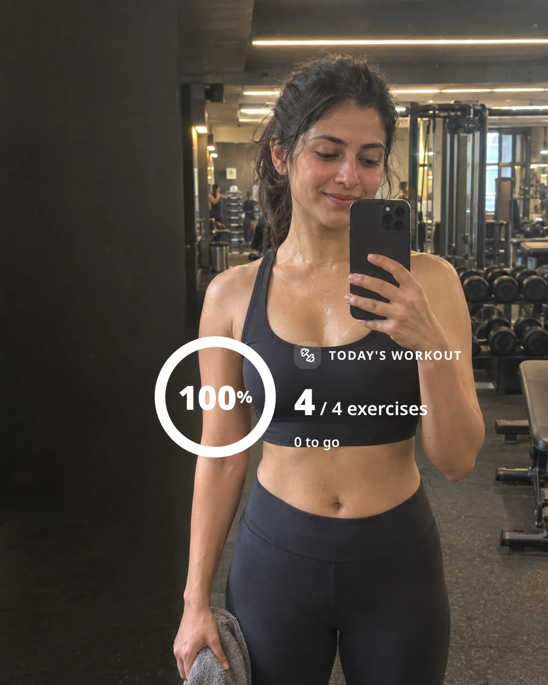 A gym mirror selfie with a NexCoach workout sticker across her midriff: 100%, 4 of 4 exercises done